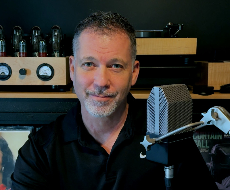 Rick Coste at his microphone, with his turntable and tube amplifier behind him